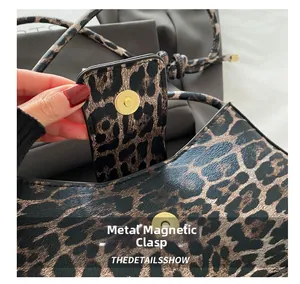 Close-up of leopard print bag featuring a gold magnetic snap buckle and leather texture