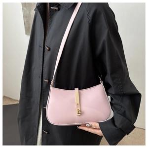 Vue détaillée du sac baguette rose minimaliste avec boucle dorée sur manteau