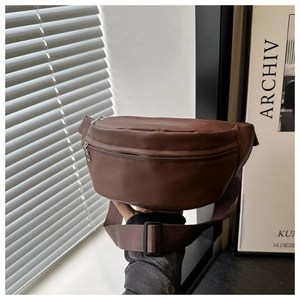 Detail of dark brown leather waist bag featuring matte finish and adjustable strap buckle