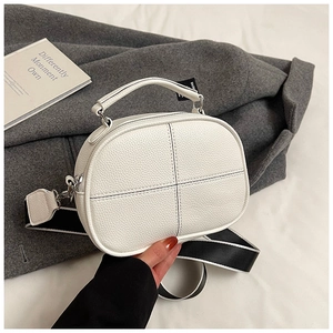 Close-up of white litchi leather texture and cross-stitch detail on the pillow bag