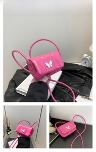 Détail du mini sac matelassé rose rouge avec ornement papillon blanc et bandoulière