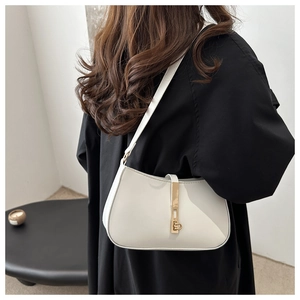 Close-up van een minimalistische crème lederen hobo-tas met een vintage gouden metalen gesp
