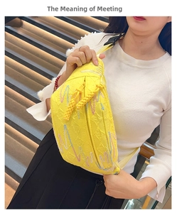 Close-up of yellow embossed corduroy dumpling bag with colorful wave embroidery and texture