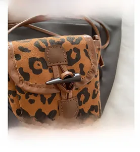Detail view of leopard print crossbody bag with vintage horn buckle and suede finish