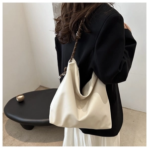 Detail view of off-white large hobo bag with distinctive brown knotted shoulder strap