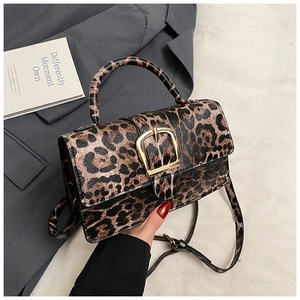 Detail view of leopard print texture and gold square buckle on a vintage handbag
