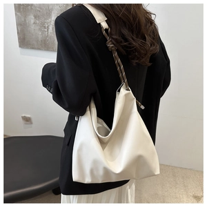 Detail of white large capacity tote bag featuring brown woven rope shoulder straps