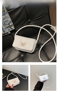 Détails d'un mini sac blanc à nœud avec un fermoir papillon en métal doré