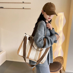 Minimalist striped canvas tote bag in cream and brown with adjustable shoulder strap
