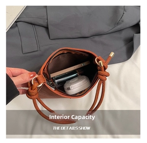 Interior capacity view of brown leather handbag showing phone and cosmetics