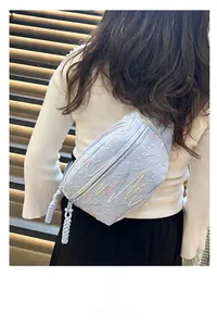 Light blue waist bag with quilted diamond pattern and colorful wave stitching detail