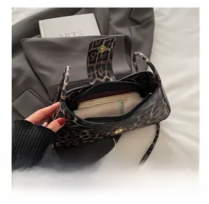 Leopard print underarm bag interior showing daily storage capacity for cosmetics