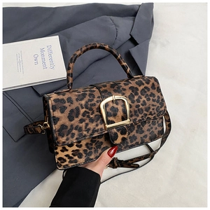 Detail of leopard print crossbody bag with golden U-shaped buckle and leather texture