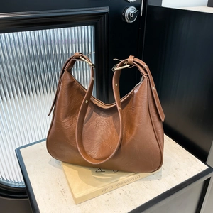 Brown leather hobo tote bag with wide strap and large capacity in a minimalist design
