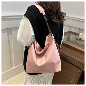 Model view of pink nylon tote bag with unique brown and white woven rope shoulder strap