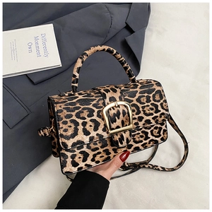 Detail of trendy leopard print handbag with prominent golden horseshoe metal buckle