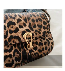 Close-up of leopard print crossbody bag with high-quality golden metal buckle detail