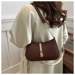 Sac sous le bras en cuir marron avec chaîne dorée sur l'épaule du mannequin, vue arrière