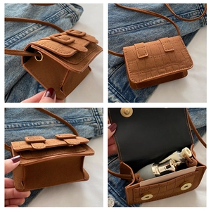 Detail view of mini brown crocodile pattern crossbody bag with secure magnetic closure