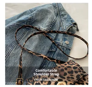 Detail view of the adjustable thin shoulder strap and buckle on leopard print crossbody bag