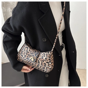 Fashion leopard print underarm bag with golden bow buckle on model in black coat