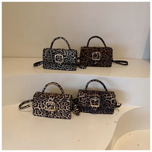 Four vintage leopard print crossbody bags in various colors on display stands