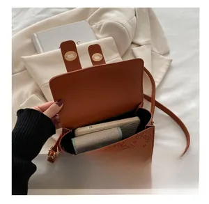 Internal capacity of brown faux leather flap bag with floral embossing and magnetic closures