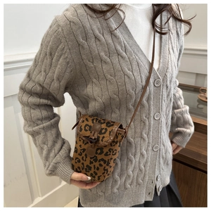 Sacoche pour téléphone à motif léopard rétro portée avec un cardigan gris et une jupe