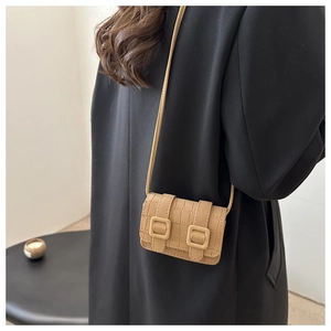 Model wearing a khaki crocodile pattern mini crossbody bag on a black winter coat