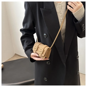 Detailed close-up of khaki mini crossbody bag with crocodile texture and dual buckles