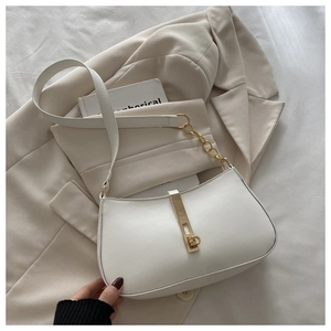 Détail d'un sac hobo blanc avec fermoir en métal doré et bandoulière en chaîne élégante