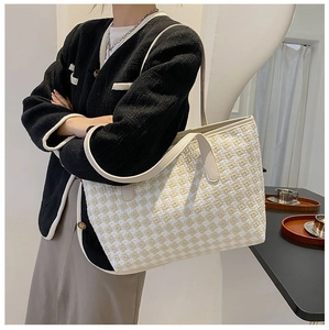 Detail of checkered woven tote bag showing large capacity and textured fabric on shoulder