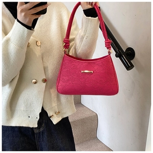 Close-up of rose pink hobo bag with lace floral embossing and knot shoulder strap detail