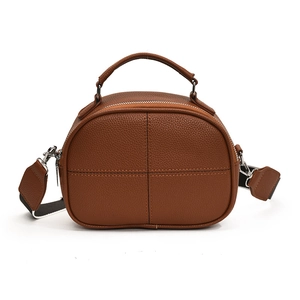 Brown pebbled leather crossbody pillow bag with cross stitching and silver hardware