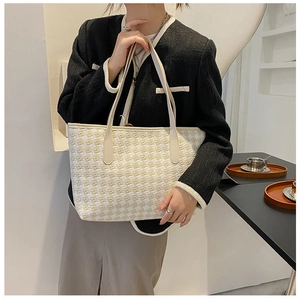 Large checkered tote bag shown on model in a stylish cafe setting for daily commute