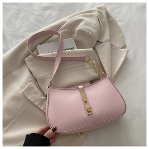 Détail du sac en cuir rose avec boucle dorée et bandoulière en chaîne élégante