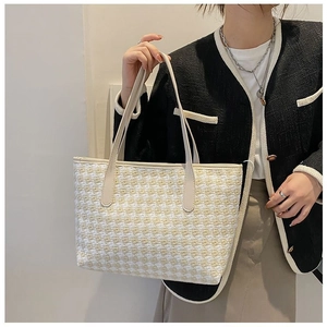 Chic tweed tote bag with beige leather handles styled with a classic plaid jacket
