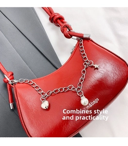Detail of red crinkled leather underarm bag with silver chain and pearl charms