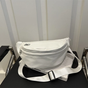 White minimalist chest bag with silver zippers and adjustable strap on a leather bench