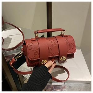 Detail of red floral embossed Boston bag featuring vintage dual gold twist locks and leather