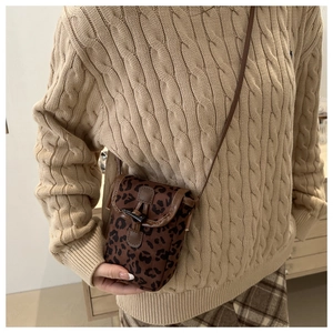 Détail du sac bandoulière en daim à imprimé léopard avec rabat et boucle foncée