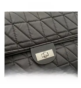 Detailed view of black quilted shoulder bag featuring a sleek silver rectangular turn-lock