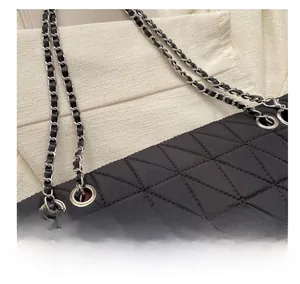 Macro detail of black quilted nylon bag showing silver eyelets and chain strap textures