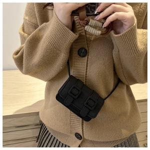 Close-up of black crocodile texture mini crossbody bag with vintage double buckles
