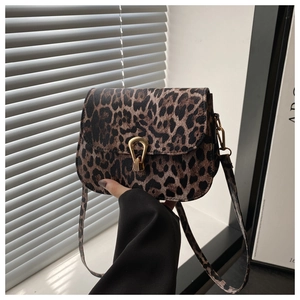 Detail of leopard print saddle bag with gold horseshoe buckle and leather strap