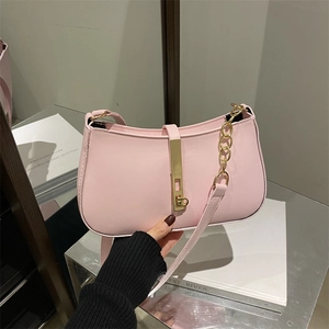 Sac sous le bras minimaliste rose avec fermoir doré et doubles bandoulières sur livre