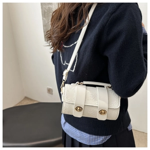 Detailed view of 3D floral embossing and dual gold twist locks on white crossbody bag
