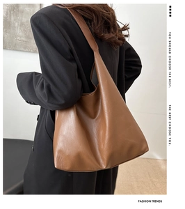 Detailed view of brown PU leather tote bag showing smooth matte texture and large capacity