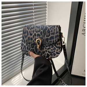 Detailed view of leopard print shoulder bag featuring a gold horseshoe buckle lock