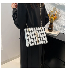 Side view of model wearing black and white plaid tweed shoulder bag with gold chain